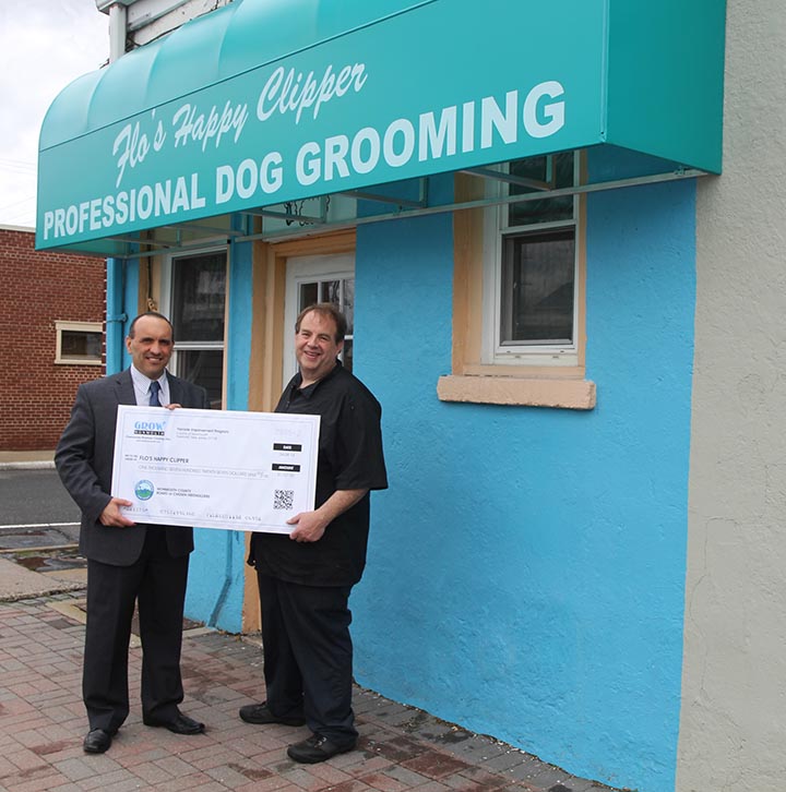 Freeholder Thomas A. Arnone presents Robert Ferrara, owner of Flo’s Happy Clipper, with a Façade Improvement Program check for $1,727 for a new awning on Tuesday, April 8, 2014 in Eatontown, NJ.